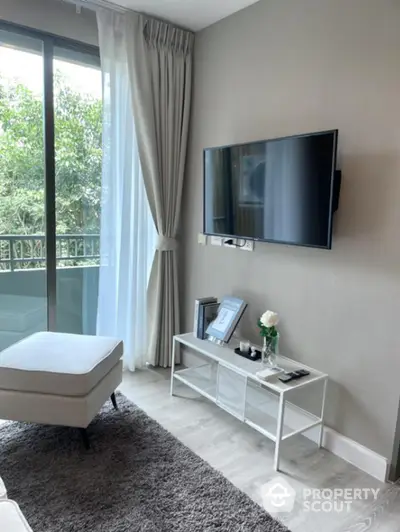 Modern living room with wall-mounted TV and balcony view