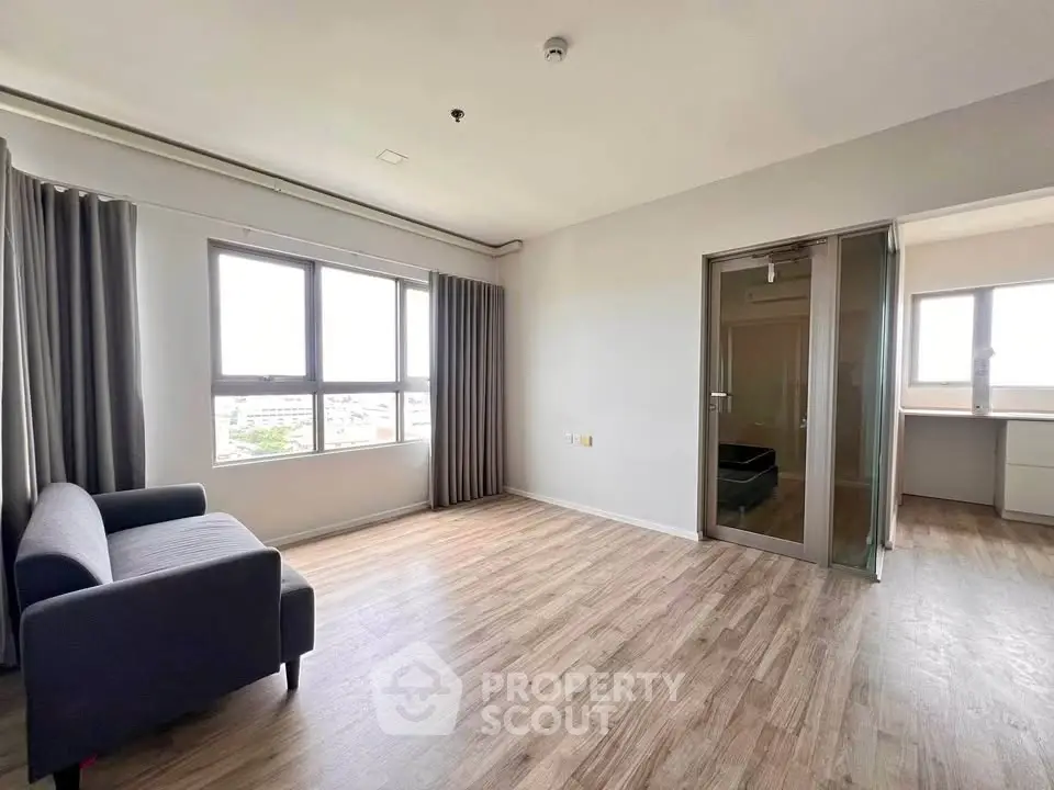 Spacious modern living room with large windows and wooden flooring