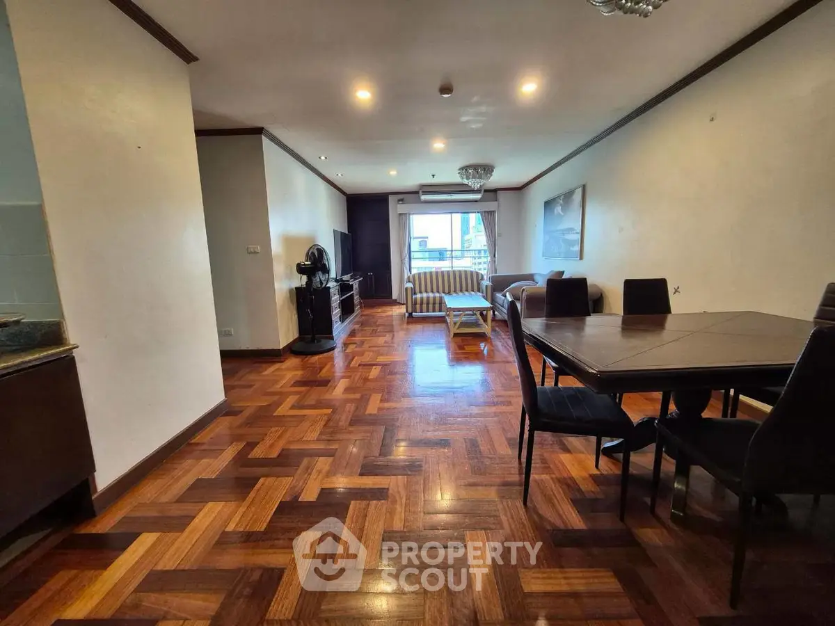 Spacious living room with elegant wooden flooring and dining area, perfect for entertaining guests.