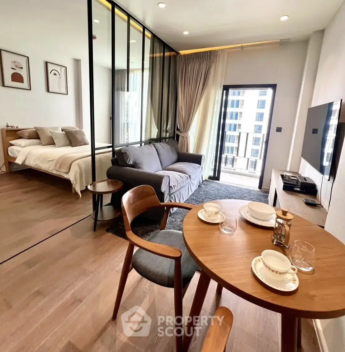 Modern open-plan living room with elegant decor and city view, featuring cozy seating and dining area.