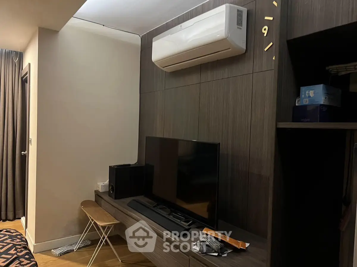 Modern living room with sleek entertainment setup and air conditioning unit.