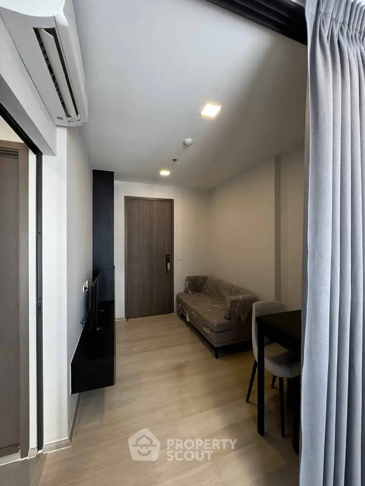 Modern living room with sleek design and air conditioning, featuring a cozy sofa and stylish flooring.