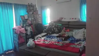 Cozy bedroom with colorful decor and ample natural light from blue curtains.