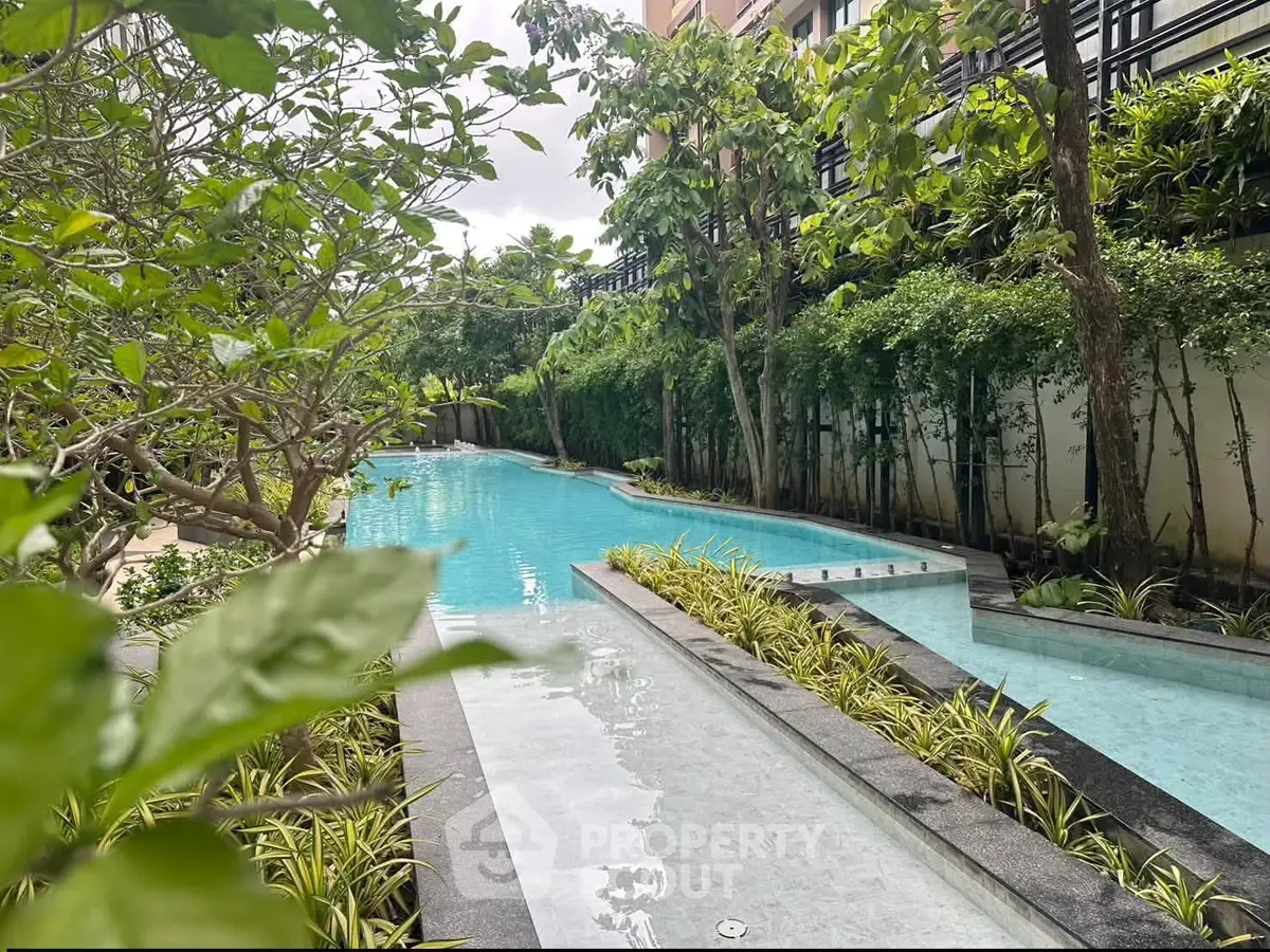 Luxurious residential pool surrounded by lush greenery and modern architecture, offering a serene oasis in the city.