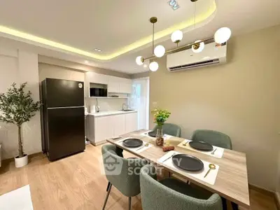Modern dining area with elegant lighting and sleek kitchen appliances in a stylish apartment.