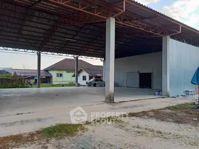 Spacious open warehouse with high ceiling and adjacent residential houses