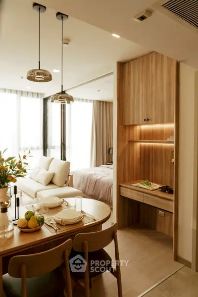 Modern open-plan living room with dining area and cozy bedroom in stylish apartment