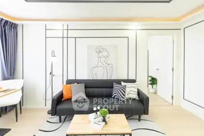 Modern living room with stylish decor and black sofa in a bright apartment