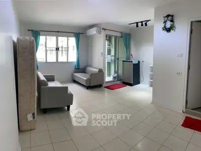 Spacious living room with modern furniture and balcony access in a bright apartment.