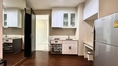 Modern kitchen with sleek appliances and open layout, featuring a built-in oven and spacious fridge.