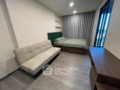 Modern bedroom with sleek design, featuring a cozy bed, stylish sofa, and elegant wooden desk.