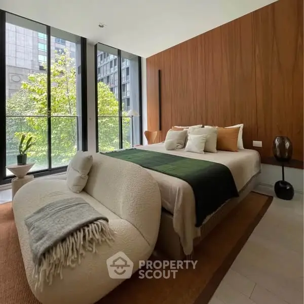 Luxurious bedroom with modern decor and large windows offering a stunning city view.