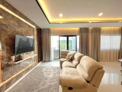 Luxurious living room with plush sofa, modern TV setup, and elegant lighting, perfect for relaxation and entertainment.