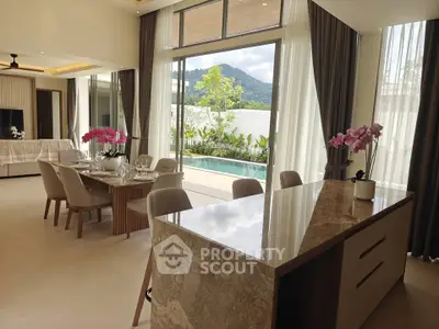 Luxurious open-plan living room with pool view and elegant dining area, perfect for entertaining.
