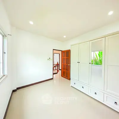 Spacious bedroom with large wardrobe and natural light in modern home