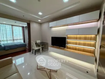 Modern living room with sleek furniture and open layout, featuring a cozy bedroom view.