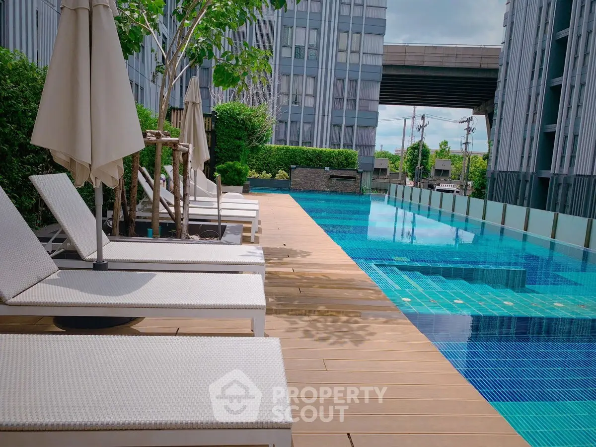 Luxurious modern apartment poolside with stylish loungers and serene ambiance.