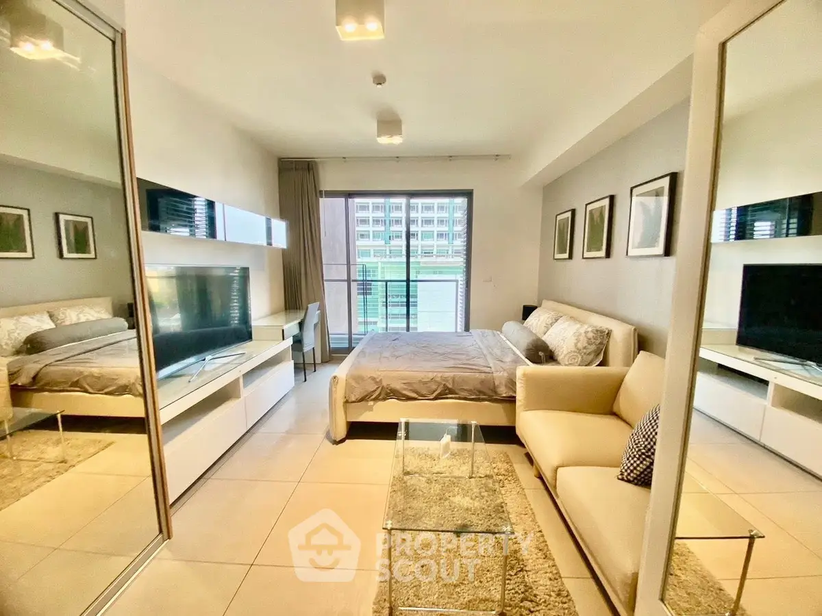 Modern studio apartment with stylish decor and large windows offering natural light and city views.