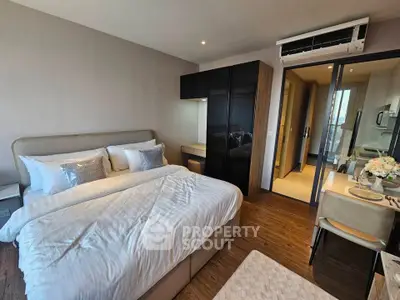 Modern bedroom with elegant decor and cozy dining area, featuring sleek furniture and warm lighting.