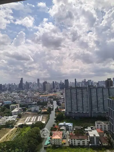 Stunning cityscape view from high-rise apartment overlooking urban skyline and river.
