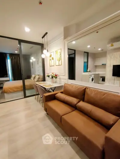 Modern living room with brown sofa and open kitchen layout, featuring stylish decor and cozy ambiance.
