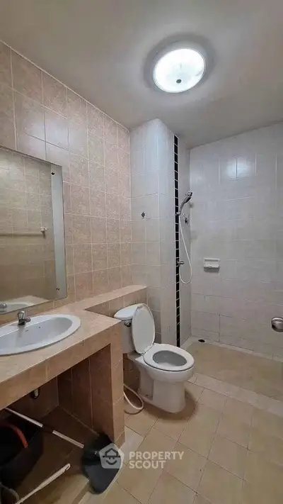 Spacious bathroom with modern fixtures and walk-in shower in a contemporary apartment.