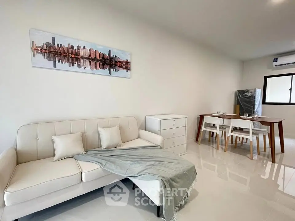 Modern living room with white sofa and dining area, perfect for urban living.