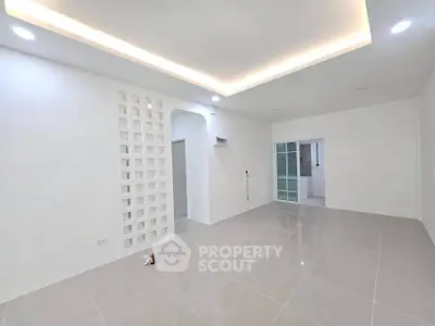 Spacious modern living room with elegant lighting and sleek tile flooring