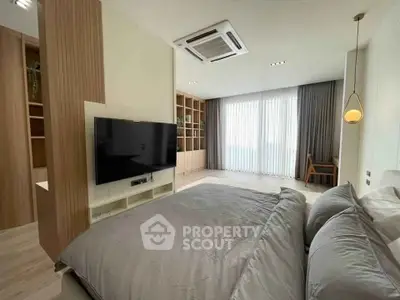 Spacious modern bedroom with large TV and elegant decor