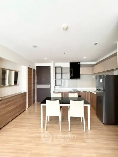 Modern kitchen with sleek cabinetry and dining area in open layout apartment