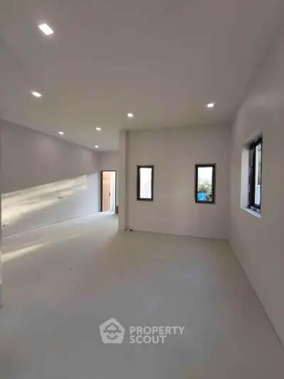 Spacious modern living room with ample natural light and minimalist design.