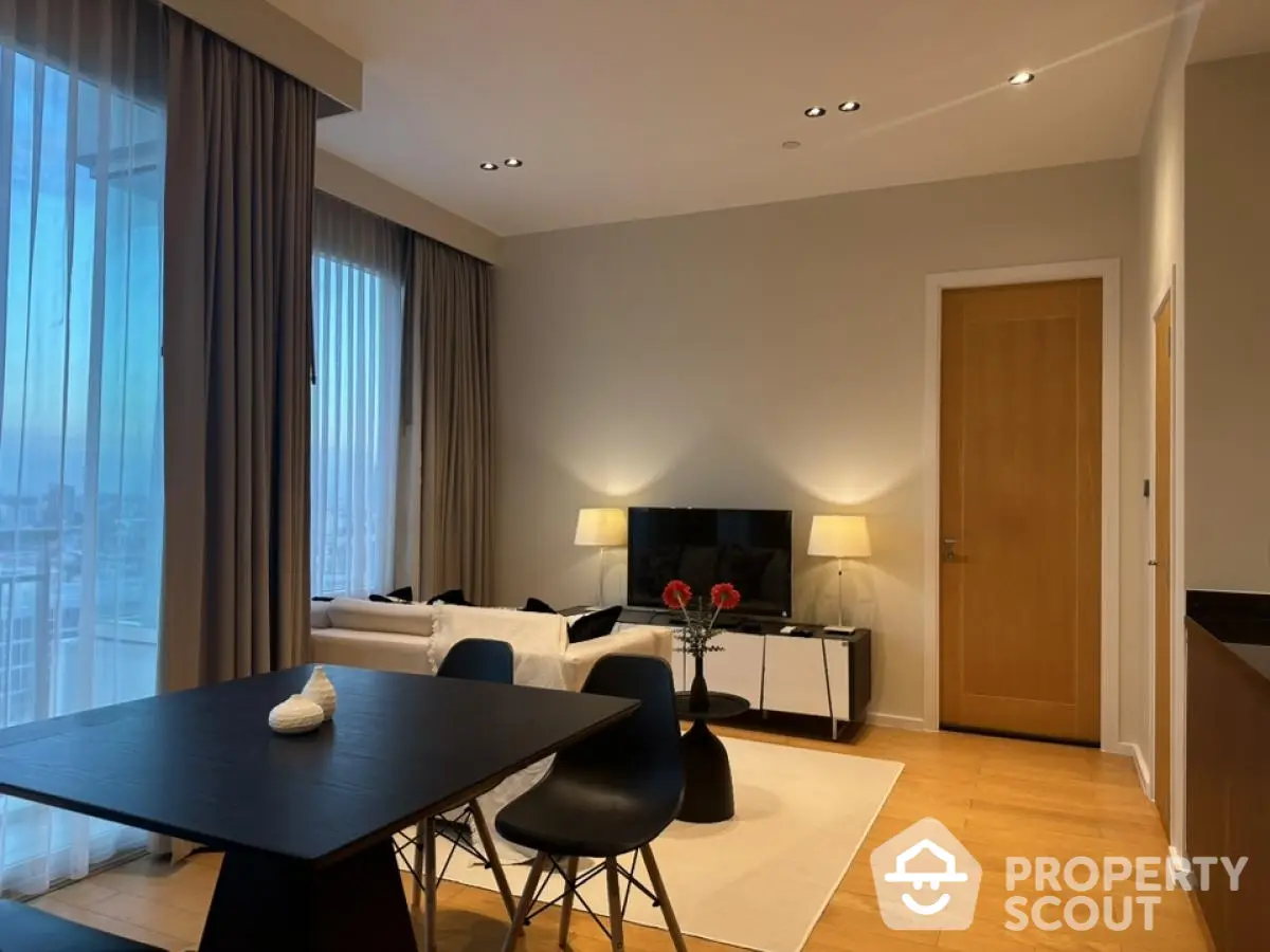 Modern living room with elegant decor and city view, featuring stylish furniture and ambient lighting.