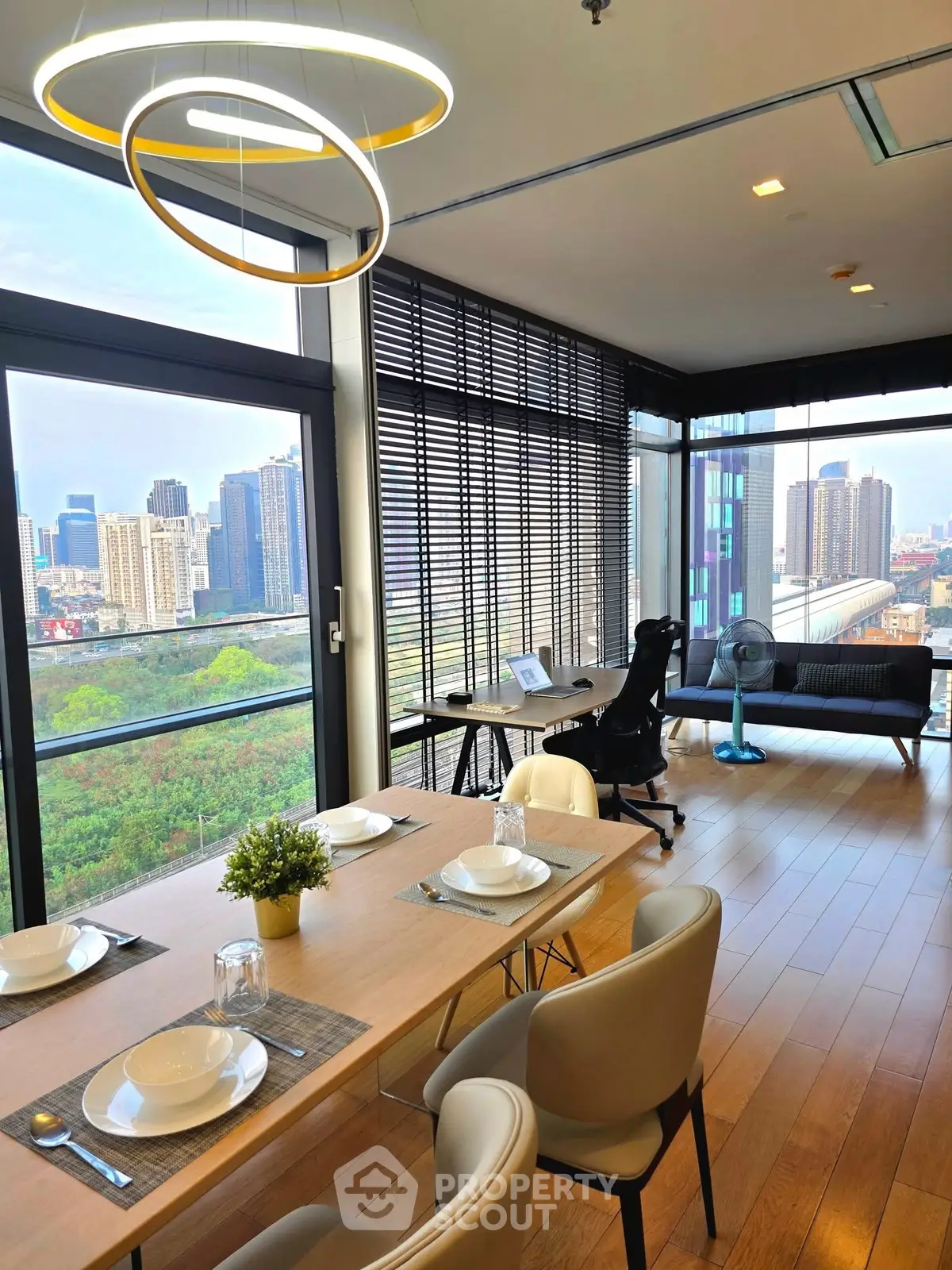 Modern open-plan living room with stunning city view and stylish dining area.