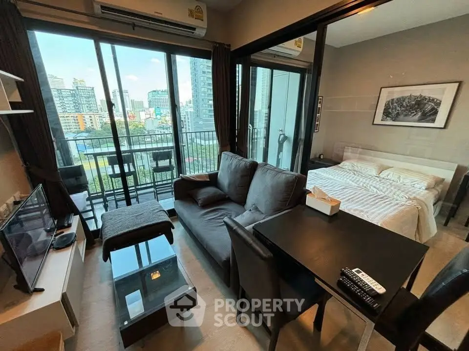 Modern studio apartment with city view, featuring cozy living area and bedroom, ideal for urban living.