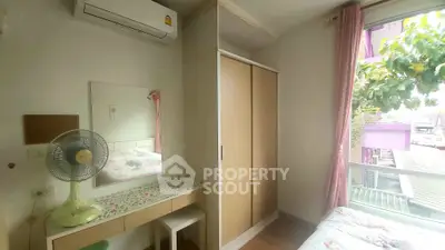 Cozy bedroom with natural light, featuring a built-in wardrobe and a charming vanity area.