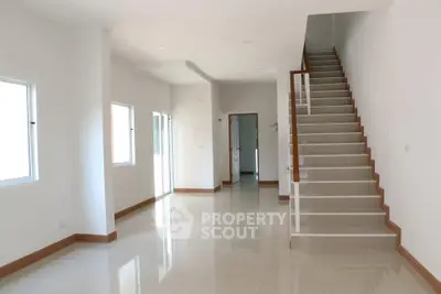 Spacious modern interior with sleek staircase and bright natural lighting