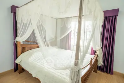 Luxurious bedroom with elegant canopy bed and rich purple curtains