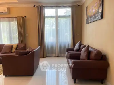 Spacious living room with elegant leather sofas and large windows