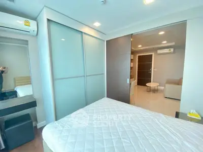 Modern bedroom with sliding closet doors and air conditioning in a stylish apartment.