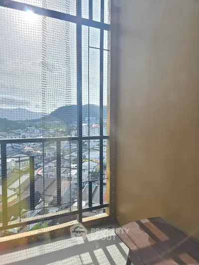 Stunning balcony view with mountain backdrop and cityscape, perfect for relaxation.