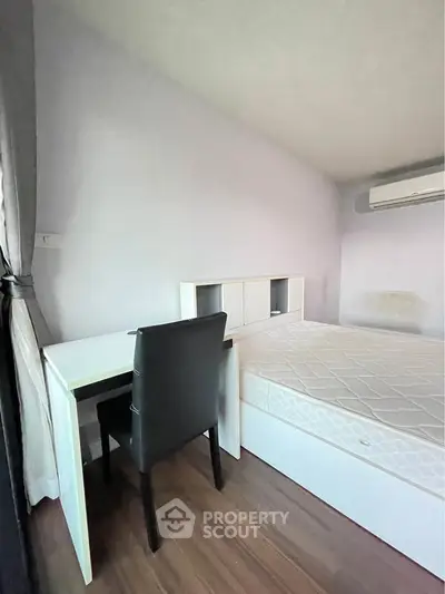 Cozy bedroom with desk and air conditioning, perfect for a comfortable living space.