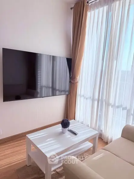 Modern living room with large TV and natural light