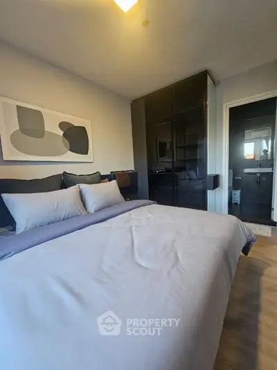Modern bedroom with stylish decor and cozy bedding in a contemporary apartment.