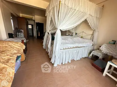 Spacious bedroom with elegant canopy bed and cozy decor