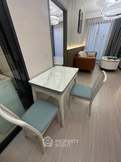 Modern living room with stylish dining area and cozy seating, featuring elegant lighting and floor-to-ceiling windows.
