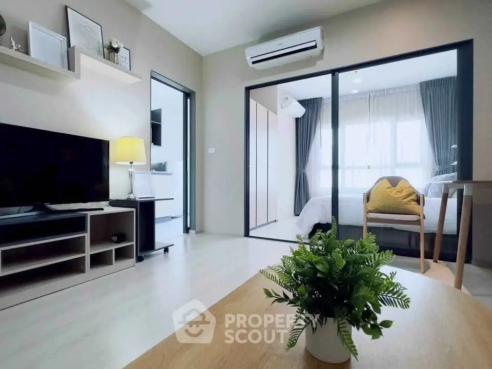 Modern living room with open layout and cozy bedroom view, featuring stylish decor and natural light.