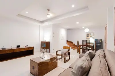 Spacious living room with modern decor and open layout, featuring elegant furniture and ambient lighting.