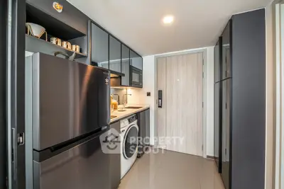 Modern kitchen with sleek appliances and ample storage in a stylish apartment.