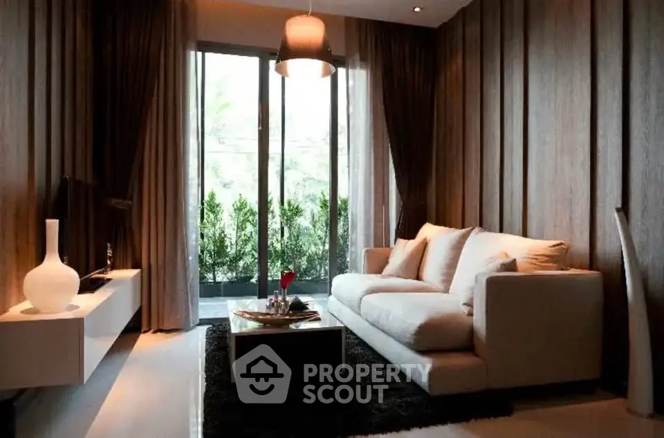 Luxurious living room with modern decor and large windows overlooking greenery.