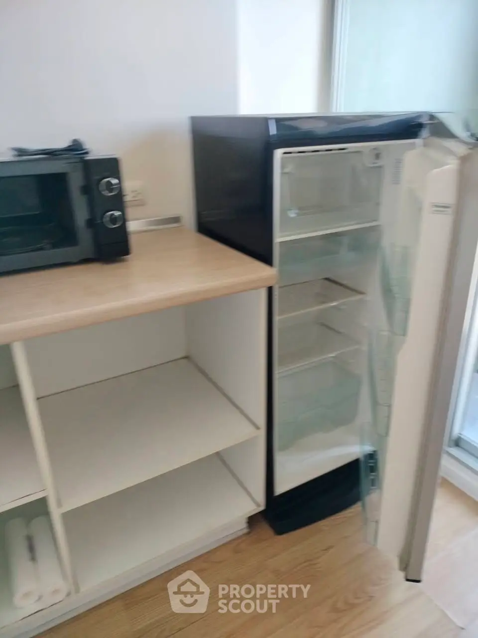 Compact kitchen with fridge and microwave, ideal for modern living.